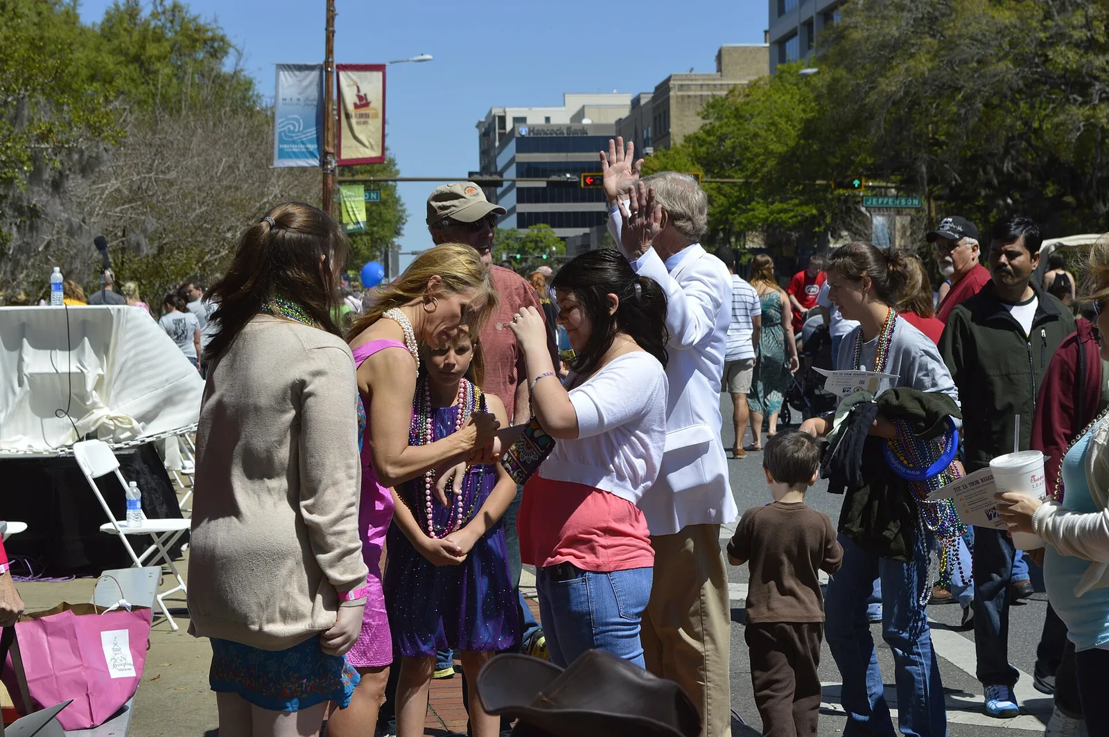 Festivalgoers in beads crowd a downtown Tallahassee street during Springtime Tallahassee.